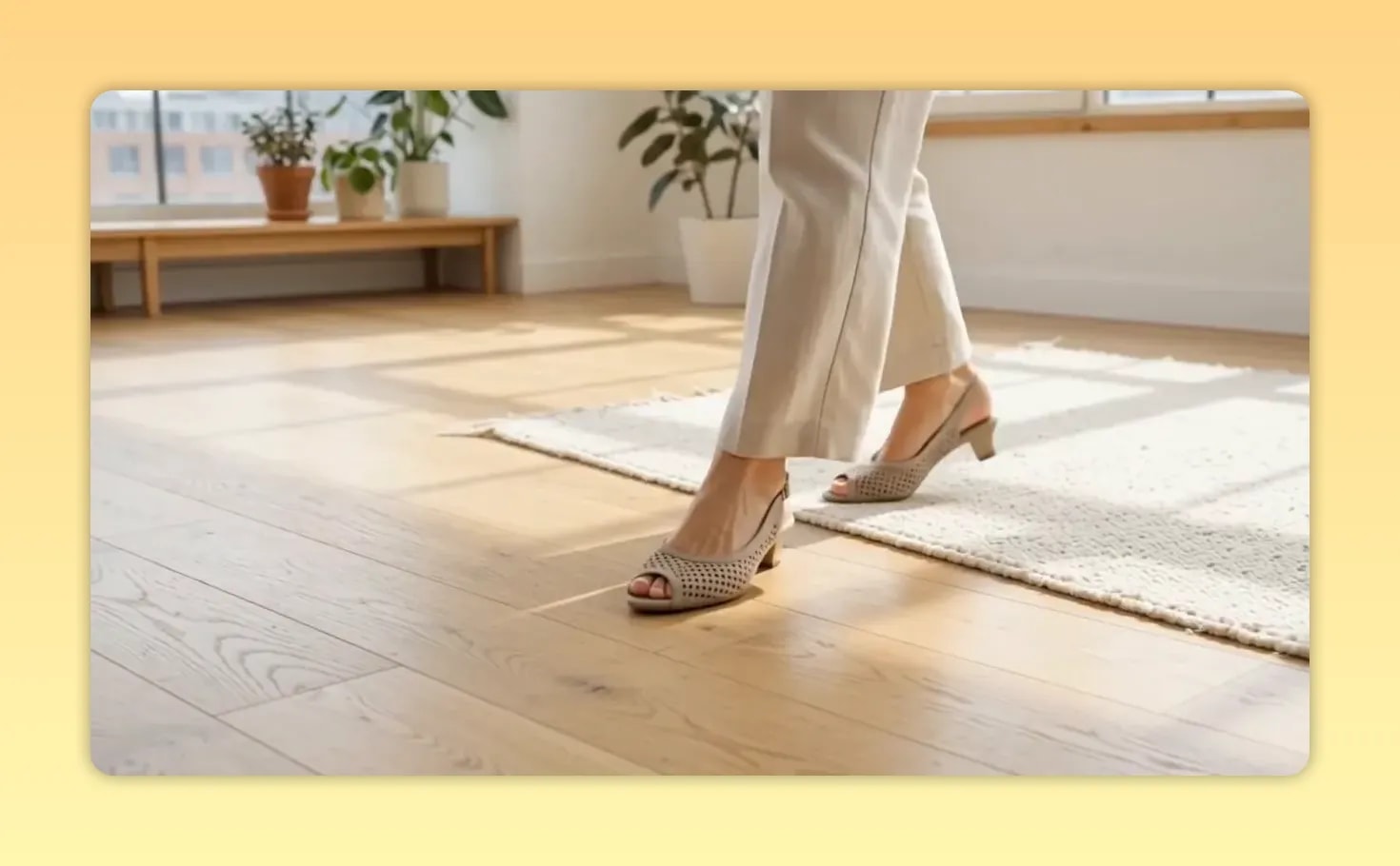 Beigefarbene Peeptoe-Schuhe mit Absatz zu heller Hose auf hellem Holzboden