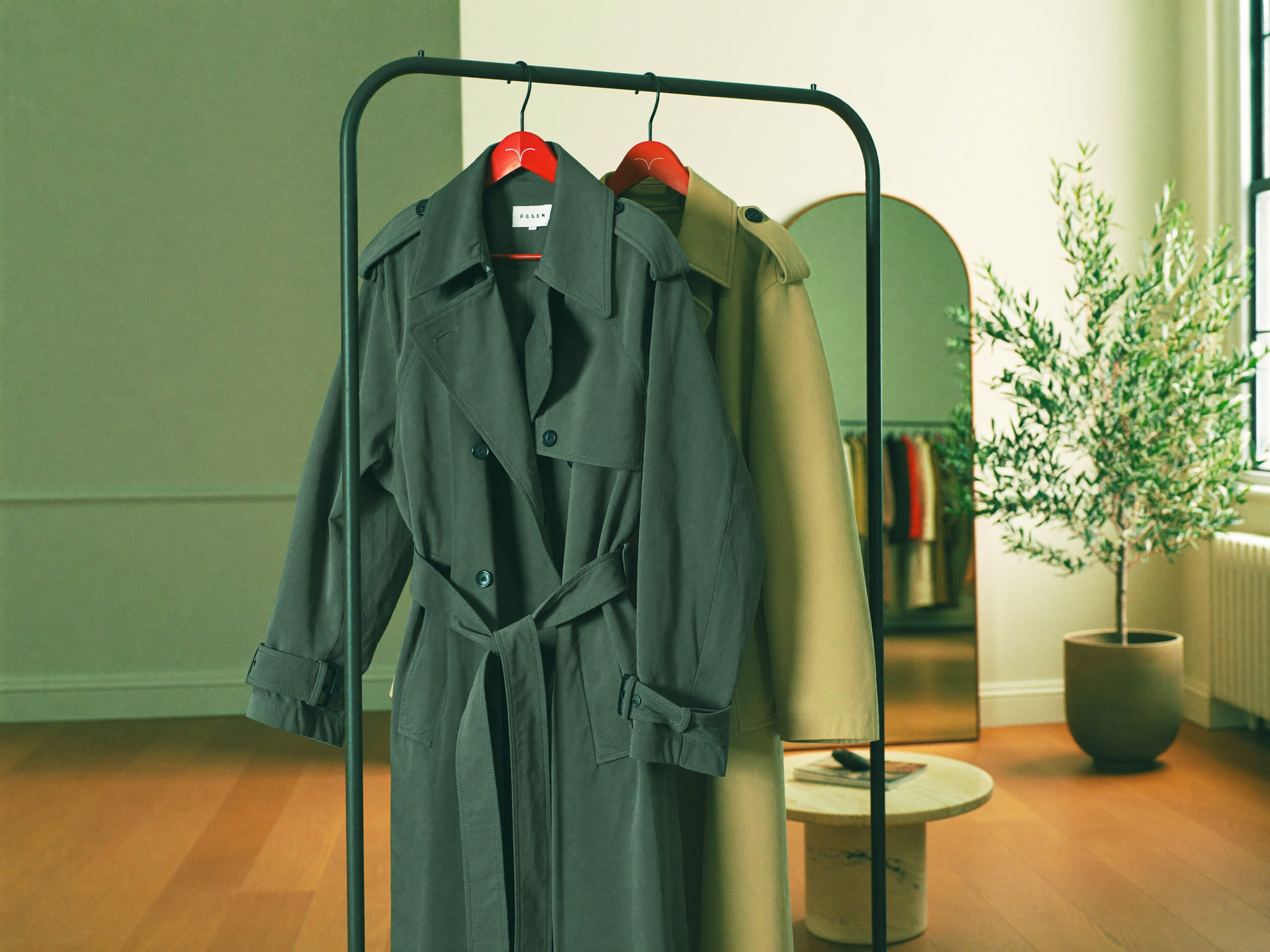 Weicher Trench und kürzerer Car Coat an einer Kleiderstange, matte Beige- und Sage-Töne, Loft, ohne Gesicht